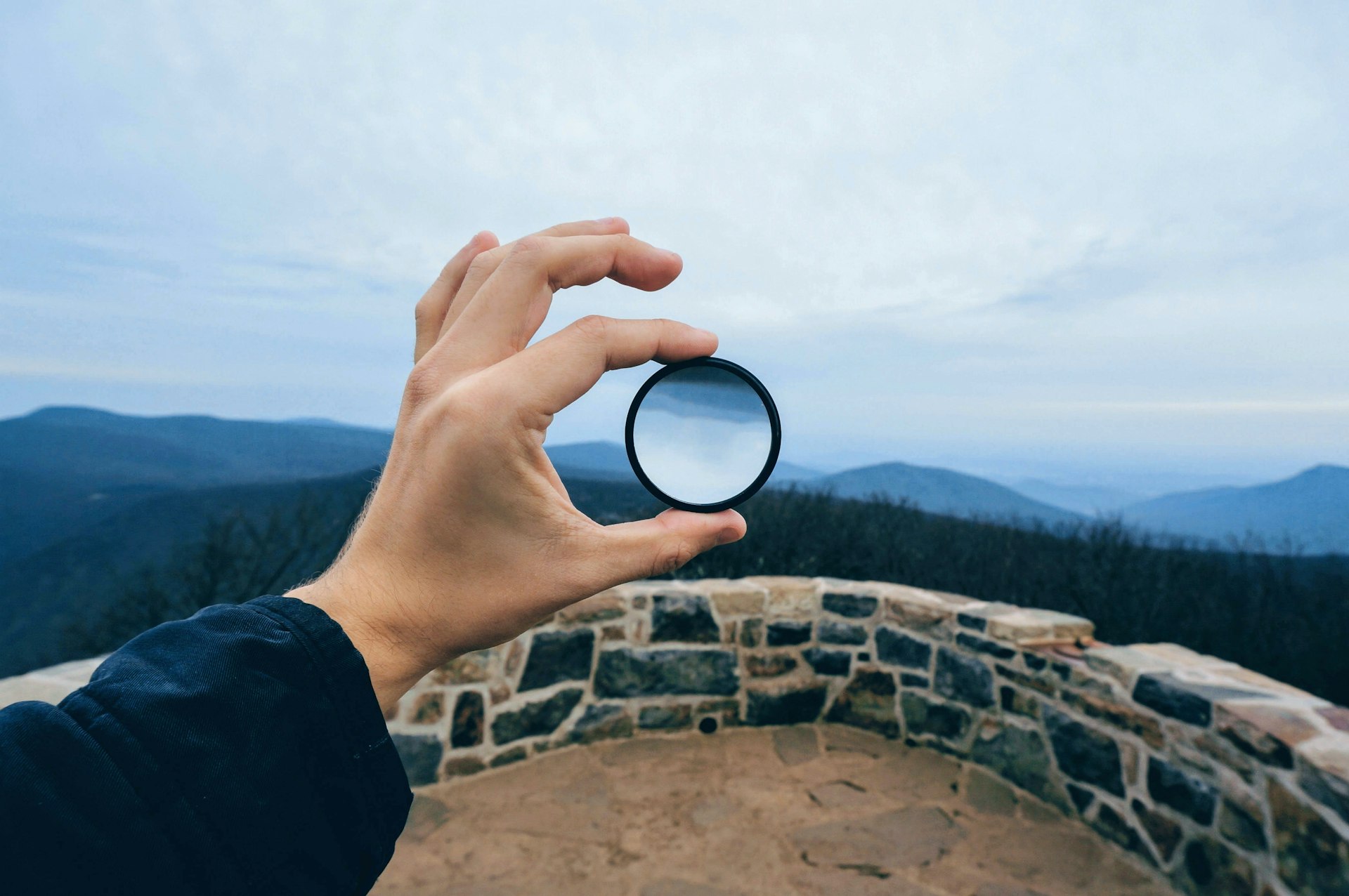 person holding round black case